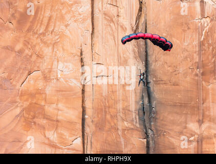 Aaron Stuyvenberg salta da un punto di uscita chiamato lapide nei pressi di Moab Utah Foto Stock