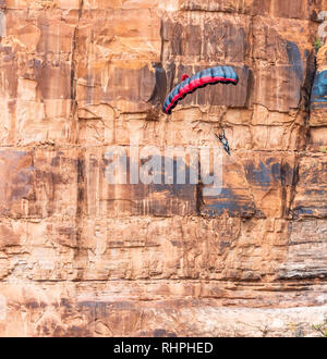 Aaron Stuyvenberg salta da un punto di uscita chiamato lapide nei pressi di Moab Utah Foto Stock