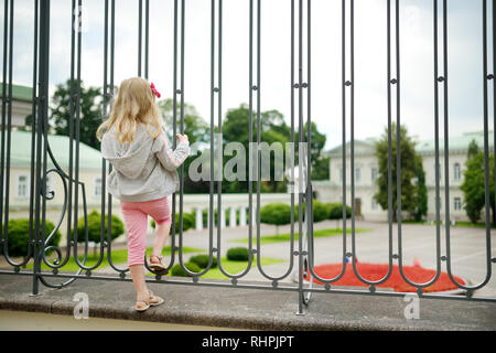 Giovane ragazza guardando il palazzo presidenziale, situato nella città vecchia di Vilnius, il Funzionario ufficio ed eventuale residenza ufficiale del Presidente di li Foto Stock