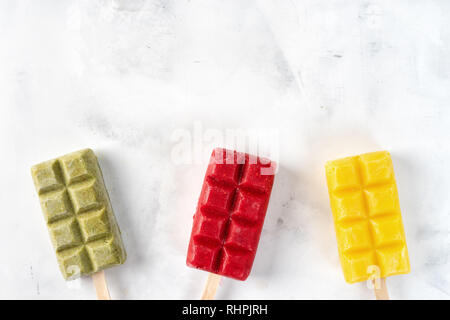 Frutta sorbetto colorati popsicles su sfondo bianco Foto Stock