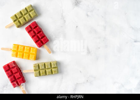 Frutta sorbetto di coloratissimi lecca lecca su sfondo bianco Foto Stock