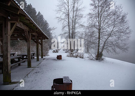 Fire pit e tavoli da picnic nella tempesta di neve Foto Stock