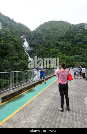 I turisti cinesi in posa di fronte a sorpresa Creek caduta, Barron Gorge, Cairns, estremo Nord Queensland, FNQ, QLD, Australia Foto Stock