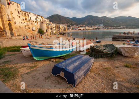 Cefalù / Sicilia - 15 settembre 2011: Persone sole al city beach, a tarda sera ampia angolazione con barche Foto Stock