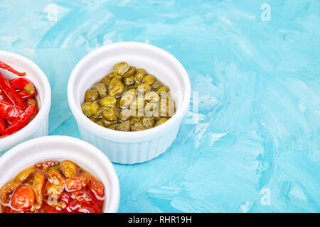 Conserve Italia - set marinata di capperi e pepe, pomodori secchi in bianco a bocce. Mediterraneo. Copia dello spazio. Foto Stock