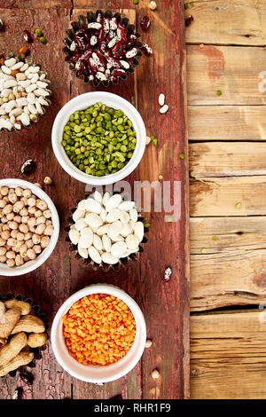 Insieme di raccolta di fagioli e legumi turco rosso lenticchie, ceci, fagioli, arachidi, piselli, lenticchie canadese su un tavolo di legno. Bocce di vari lenticchie. Foto Stock
