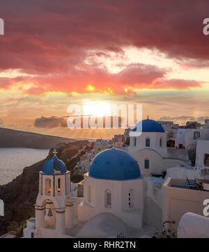 Villaggio di Oia con chiese contro il tramonto su Santorini isola in Grecia Foto Stock