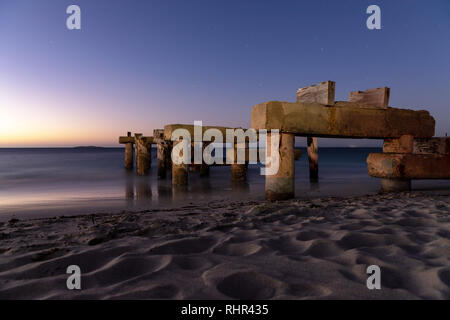 Una lunga esposizione del vecchio molo /pier su una tranquilla notte estiva in Jurien Bay Australia Occidentale Foto Stock