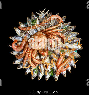 Big hairy granchio bollito siede su un mucchio di essiccato pesce salato su un regalo bouquet su sfondo nero, vista dall'alto Foto Stock