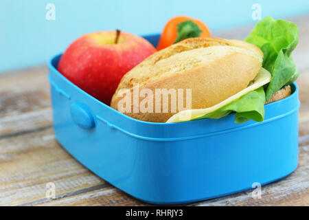 Un sano pranzo al sacco contenente formaggio rotolo, croccante di peperone giallo e rosso apple Foto Stock