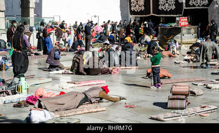 Buddista Tibetana pellegrini prostrarsi davanti al monastero di Jokhang, Lhasa, in Tibet Foto Stock