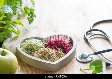 Germogli vegetali ed erbe nel cuore uno stile di vita sano e medicina alternativa nozione Foto Stock