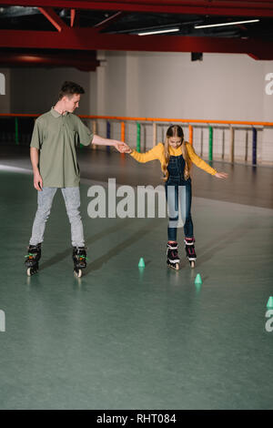 Bel giovane allenatore dando istruzioni al bambino attraente Foto Stock