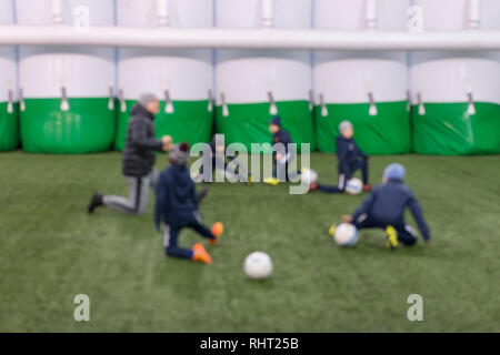 Allenamento di calcio i bambini. Squadra di calcio di ragazzi adorabili esercitando sul passo di verde su strutture speciali. sfocata Foto Stock