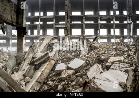 Un enorme pila di cemento grigio di detriti da pile e le pietre del distrutto edificio. L'impatto della distruzione. Foto Stock