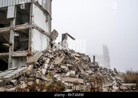 Un enorme pila di cemento grigio di detriti da pile e le pietre del distrutto edificio. Copia dello spazio. Foto Stock