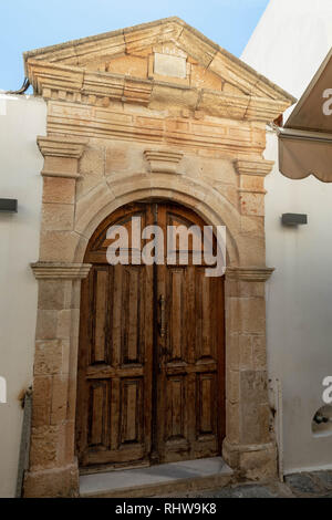 Punto di ingresso per accedere a un edificio 1916 a Lindos, Grecia. Eventualmente un edificio religioso con una rosa e la placca a croce sopra la porta. Foto Stock