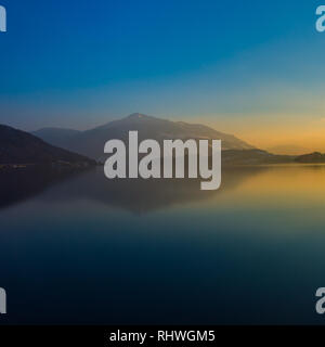 Riflessioni del Monte Rigi sul lago di Zugo nella luce della sera, cielo blu, acqua Foto Stock