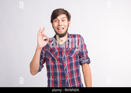 I gesti, i segni e le persone concetto - sorridente confuso uomo mostra okay segno su sfondo bianco Foto Stock