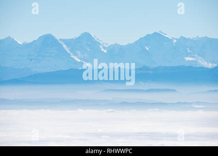 Mare di nebbia con alpi su Mittelland Svizzera visto da Grenchenberg con Eiger, Mönch e Jungfrau Foto Stock