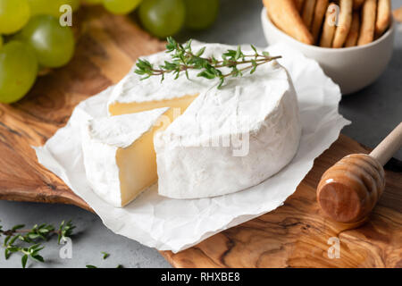 Gustoso Formaggio Brie o formaggio Camembert su legno di oliva serve Board. Primo piano Foto Stock