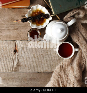 Tazza di tè con dolcezza siberiano - coni di zucchero, teiera e vecchi libri sullo sfondo di legno, concetto di accogliente teatime, autunno inverno weekend, tempo libero t Foto Stock