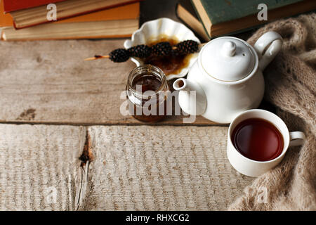 Tazza di tè con dolcezza siberiano - coni di zucchero, teiera e vecchi libri sullo sfondo di legno, concetto di accogliente teatime, autunno inverno weekend, tempo libero t Foto Stock