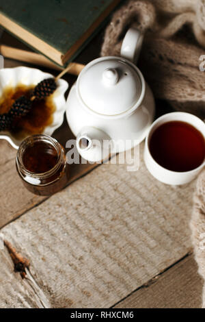 Tazza di tè con dolcezza siberiano - coni di zucchero, teiera e vecchi libri sullo sfondo di legno, concetto di accogliente teatime, autunno inverno weekend, tempo libero t Foto Stock