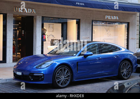 Blu sport Porsche auto parcheggiate al di fuori del negozio Prada a Monaco, Francia Foto Stock