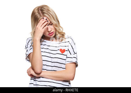 Sottolineato esaurito giovane studentessa avente mal di testa. Sensazione di pressione e di stress. Premuto studente con testa in mani su sfondo bianco. Foto Stock