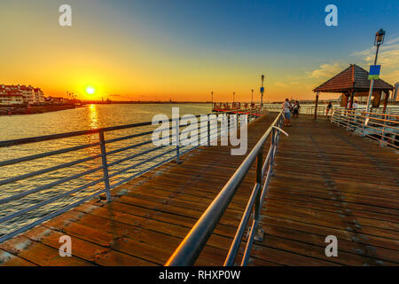 Scenic tramonto sulla baia di San Diego dal vecchio molo in legno in Coronado Island, California. Cittadini e turisti la pesca e passeggiate e godendo della vista Foto Stock