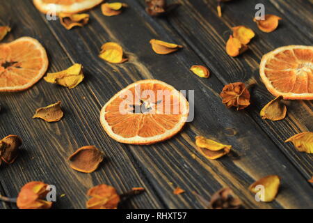 Fette di arancia e ibisco Petali su sfondo di legno. Foto Stock