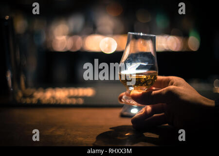 Immagine ravvicinata di una mano che tiene un Glencairn single malt whisky in vetro. Foto Stock