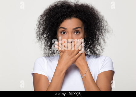 Scioccato spaventata donna africana con sorpresa faccia bocca di copertura Foto Stock
