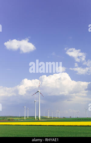 Wind Farm con la filatura turbine eoliche nel mezzo di terreni agricoli di coltura intensiva produzione sostenibile e le fonti rinnovabili per la produzione di energia e di ecologia e e Foto Stock