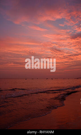 Tramonto sulle acque al largo della costa della spiaggia di Mui Ne nel centro sud Binh Thuan Provincia, Vietnam Foto Stock