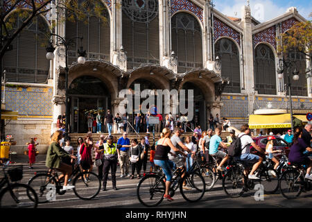 Donna di polizia sventolando i ciclisti del passato al di fuori del mercato centrale di Valencia Spagna Foto Stock