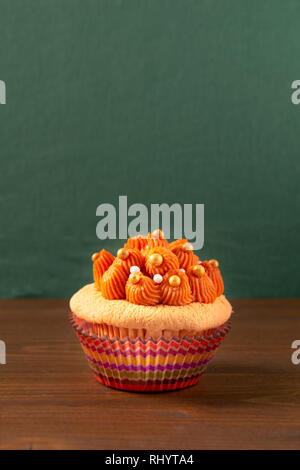 Cibo fatto in casa Thai ice tea cupcake sulla tavola di legno e lo sfondo di colore verde con spazio di copia Foto Stock