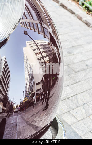 La riflessione di un edificio di strada su un viola, lucidato vecchia auto, bella prospettiva speculare di un paesaggio urbano Foto Stock