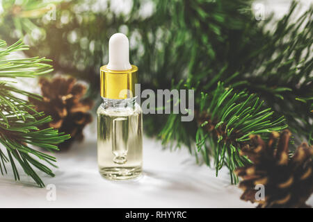 Olio essenziale bottiglia con pine ramo di albero e anello interno con rulli conici Foto Stock