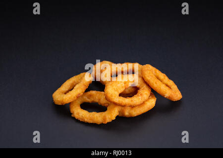 Calamari fritti anelli sullo sfondo nero Foto Stock