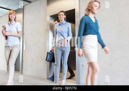 I professionisti aziendali a piedi di ascensore in office Foto Stock