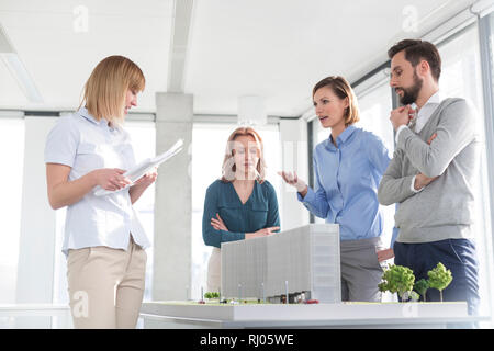 Colleghi di lavoro discutendo su progetto alla scrivania in ufficio Foto Stock