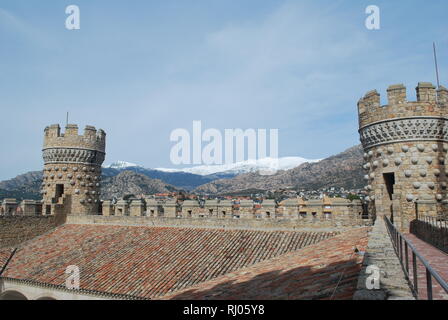 La vista delle montagne e le torrette sulla terrazza sul tetto del castello di Manzanares el Real in Spagna centrale Foto Stock