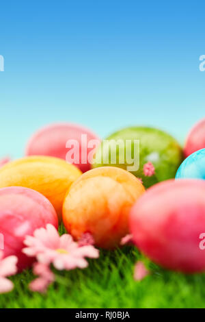 Molte colorate uova di pasqua giacciono sul prato per la pasqua Foto Stock