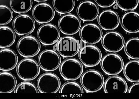 Raccolta di spazzolato anelli metallici isolati su sfondo nero. Sacco di brillare gli anelli in metallo. Foto Stock