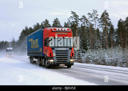 Salo, Finlandia - 18 Gennaio 2019: Rosso Scania R420 semi rimorchio Marjamaki e un altro carrello unità sul nevoso inverno autostrada nel sud della Finlandia. Foto Stock