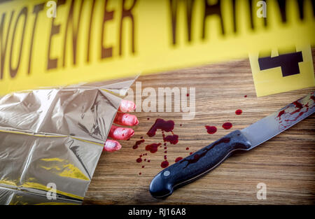 Omicidio scena per arma da taglio, sanguinolento mano lungo con un coltello con sangue, immagine concettuale Foto Stock