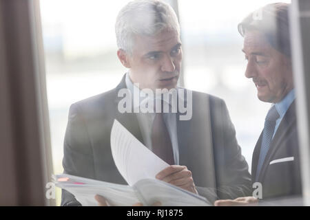 Imprenditori maturi discutendo su documento nel nuovo ufficio Foto Stock