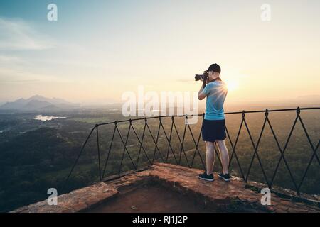 Giovane fotografo al tramonto. Vista dalla Roccia di Sigiriya in Sri Lanka. Foto Stock